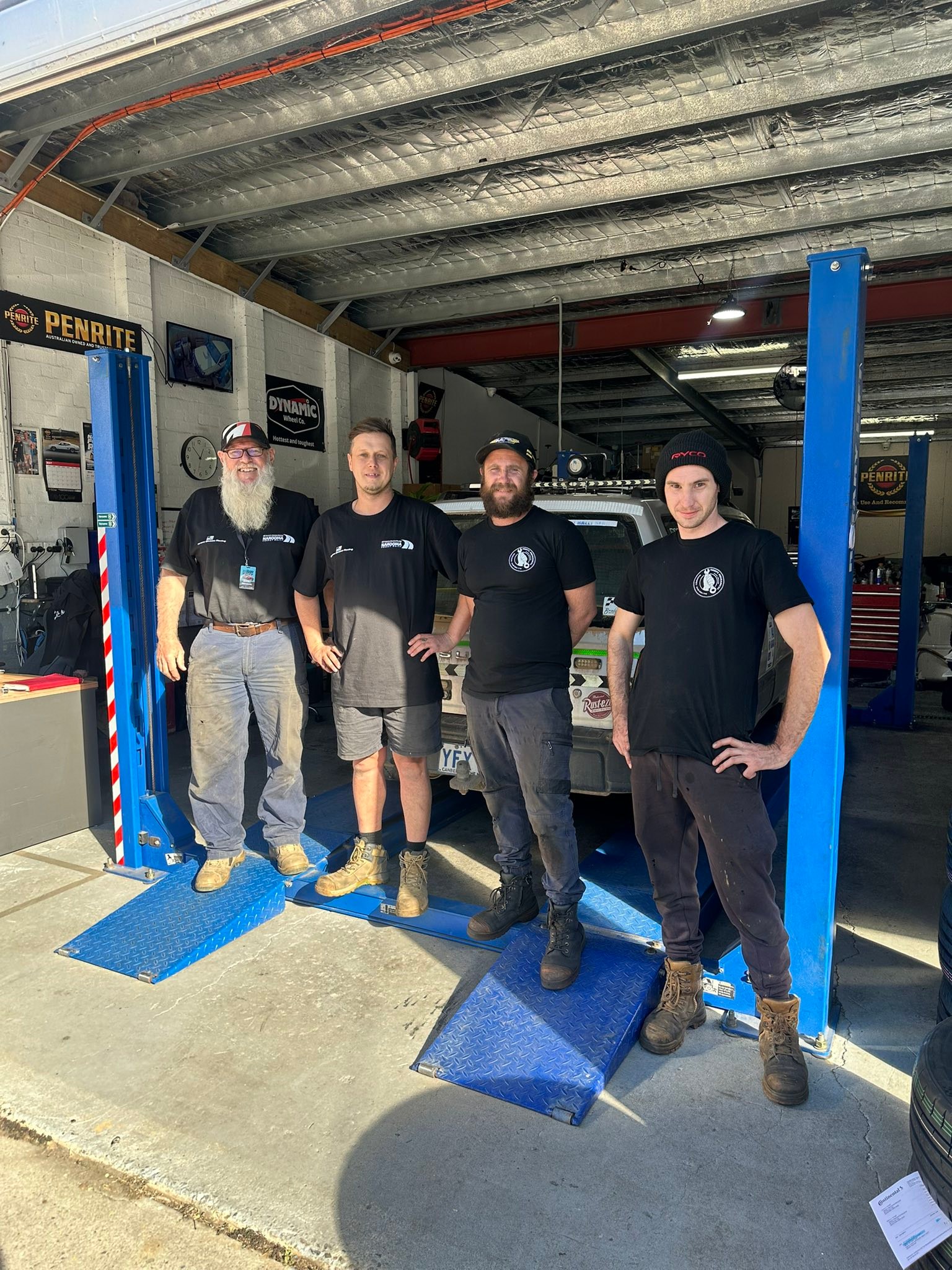The Reidy's Mechanical team standing on the hoist ramps inside the Narooma workshop