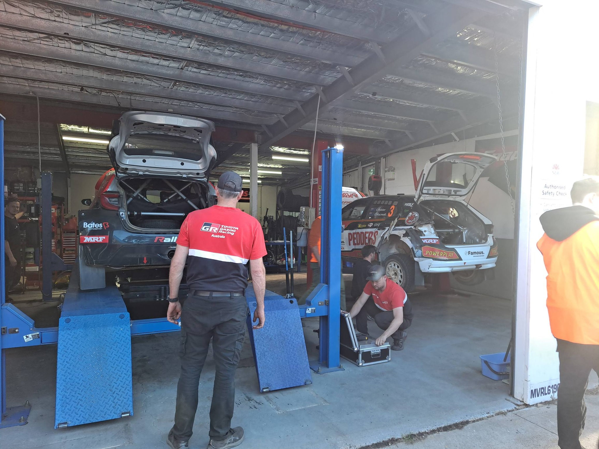 Rally cars up on the hoists inside the Narooma workshop